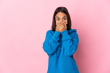 Young latin woman isolated on pink background covering mouth with hands