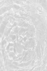 White water with ripples on the surface. Defocus blurred transparent white colored clear calm water surface texture with splashes and bubbles. Water waves with shining pattern texture background.