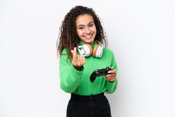 Young Arab woman playing with a video game controller isolated on white background making money gesture