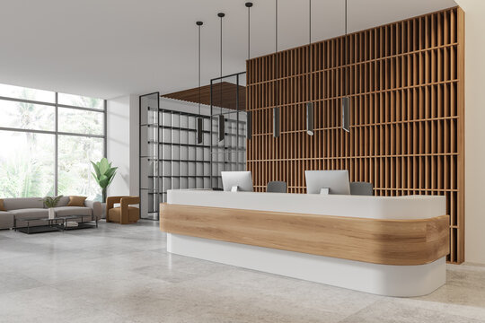 Office interior reception desk with pc computers and armchairs, panoramic window