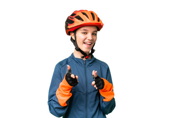 Teenager cyclist girl over isolated chroma key background pointing to the front and smiling