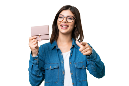 Young Russian woman holding a wallet over isolated chroma key background points finger at you with a confident expression