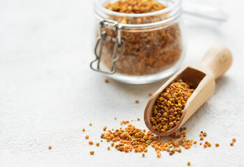 Healthy bee pollen grains.  Bee pollen on a wooden spoon and glass jar.