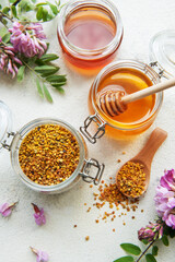 Raw organic bee pollen and honey in jars.