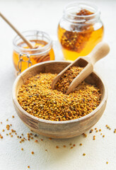 Raw organic bee pollen and honey in jars. .