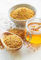 Raw organic bee pollen and honey in jars. .