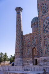 A tall building with a blue dome and a blue and white pattern on the side. The building is...