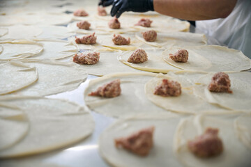 Employee forms pancakes with minced meat