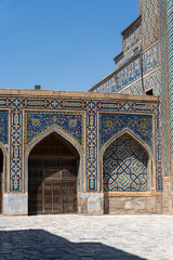 The building has a blue and white color scheme. The archway is ornate and the door is open