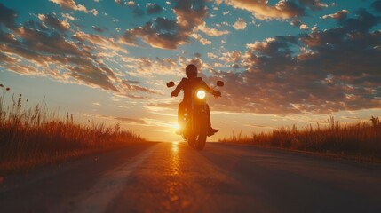 A motorcyclist rides along an open highway at sunset.