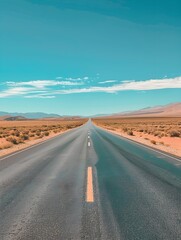 Fototapeta premium A straight, endless road cuts through a vast desert landscape under a clear, blue sky, creating a sense of isolation and adventure
