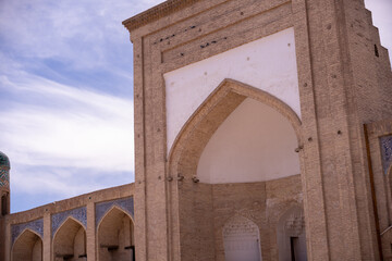 The building has a lot of arches and is very old. The arches are blue and white
