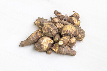 Pile of fresh harvested taro root or kochur mukhi isolated on light white background.