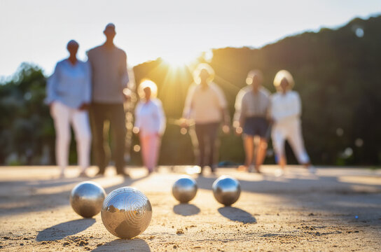 Metal balls from the petanque game that a group of elderly people are having fun with during the afternoon in the park.