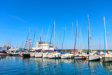 Fototapeta premium Sailboats are moored at the harbor. Boats docked at a marina with calm water