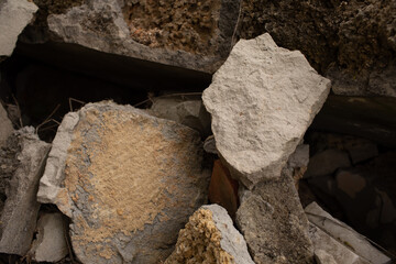 broken stone wall, pieces of stone of different sizes and colors.