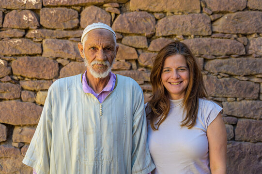 Elderly Moroccan man and middle-aged woman smiling outdoors