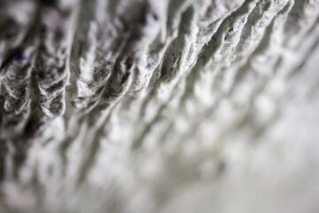 Extreme close up of old gray handmade paper mache with a structure and rough texture.