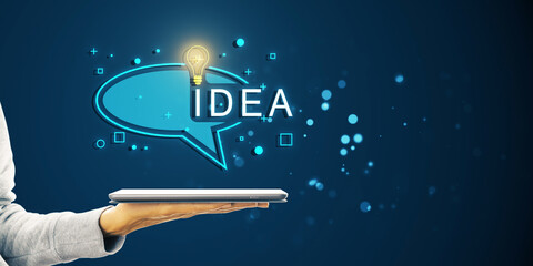 A hand holding a tablet with a bright lightbulb and IDEA caption in a speech bubble on a blue background, symbolizing inspiration and innovation