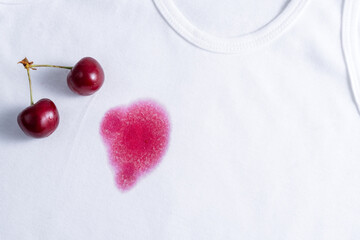 Spilled cherry juice on white clothes. Dirty food stains on clothes. Daily life dirty stain concept. top view. top view.