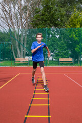 An athlete does special running exercises on a ladder.