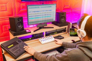 asian male sound engineer, producer, editor mixing music tracks in post production, recording studio