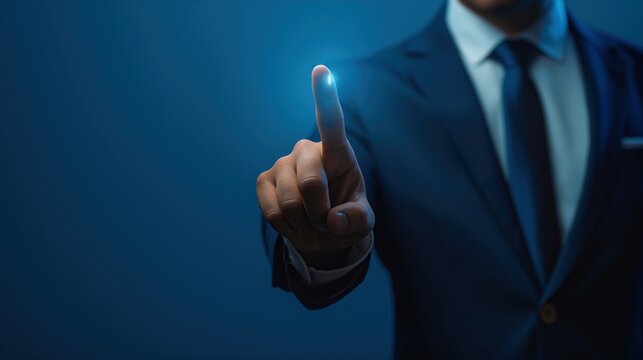 Businessman in suit touching screen with finger on blue background - Powered by Adobe