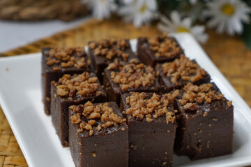 Kuih kole kacang, a steamed Malaysian cake, made with fried green bean flour, coconut milk, and palm sugar.  The decoration of the cake is from coconut oil grease or residue. Selective focus.