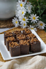 Kuih kole kacang, a steamed Malaysian cake, made with fried green bean flour, coconut milk, and palm sugar.  The decoration of the cake is from coconut oil grease or residue. Selective focus.