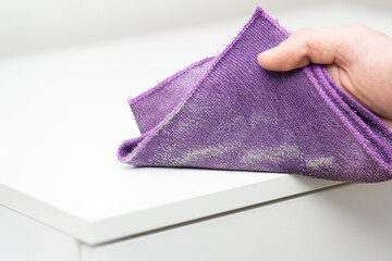 close up of a male hand wiping dust with microfiber towel cloth on white surface wardrobe, dust...