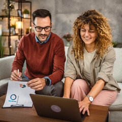 Two colleagues man and woman work together at home on laptop