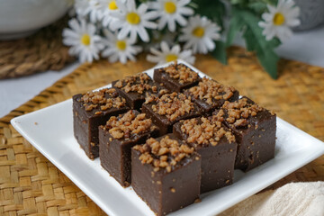 Kuih kole kacang, a steamed Malaysian cake, made with fried green bean flour, coconut milk, and palm sugar.  The decoration of the cake is from coconut oil grease or residue. Selective focus.