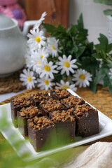 Kuih kole kacang, a steamed Malaysian cake, made with fried green bean flour, coconut milk, and palm sugar.  The decoration of the cake is from coconut oil grease or residue. Selective focus.