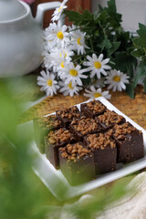 Kuih kole kacang, a steamed Malaysian cake, made with fried green bean flour, coconut milk, and palm sugar.  The decoration of the cake is from coconut oil grease or residue. Selective focus.