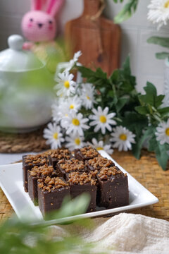 Kuih kole kacang, a steamed Malaysian cake, made with fried green bean flour, coconut milk, and palm sugar.  The decoration of the cake is from coconut oil grease or residue. Selective focus.
