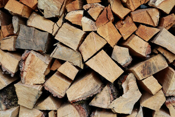Pile of wood logs, closeup of clean cut of chopped firewood logs. Natural wooden background