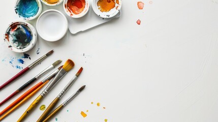 Watercolor painting tools on white table with space for text