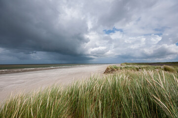 Cold sunny weather with storm and heavy clouds on the beach of the island of Schiermonnikoog, in June 2024  ,The Netherlands.