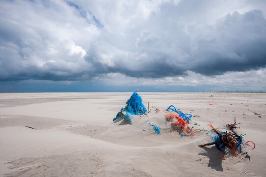 Cold sunny weather with storm and heavy clouds on the beach of the island of Schiermonnikoog, in June 2024  ,The Netherlands.Waste on the beach