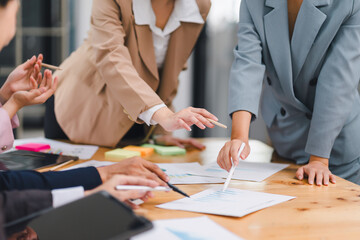 Close-up shot of diverse business team collaboratively analyzing reports and discussing data during meeting in office.