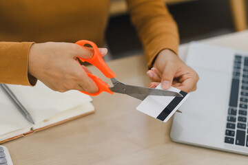 Close-up of a person cutting a credit card with scissors, symbolizing financial management, debt...