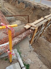 Rusty pipes. Repair and replacement of the pipeline. Water supply, heating mains underground. The earth was excavated at a construction site. Close-up.
