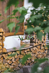 firewood. A beautiful corner of a country house. The facade is decorated with firewood. A variant of stacking firewood on the facade of the house.
