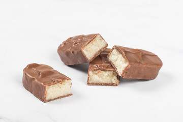 Candy bar with coconut pulp, in milk chocolate. White background. Close-up.