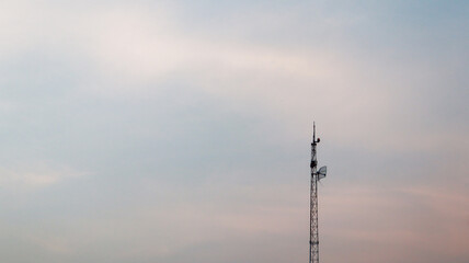 Obraz premium Background of signal transmitting tower in the afternoon with golden hours sky and sunset view, high contrast and silhouette of Telecommunication Tower Against a Blushing Sky