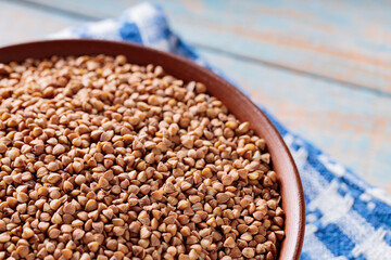 Wholegrain Buckwheat in Brown Bowl on Linen Napkin, Close Up