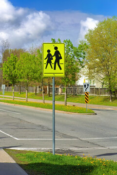 A yellow pedestrian crossing sign with figures indicating a safe crossing area