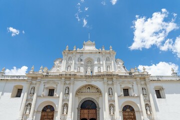 Fototapeta premium amazing and large white church facade showing sculptures of saints arches columns and doors during a bright sunny day