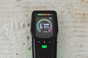 Moisture meter on a concrete floor. Moisture detector.