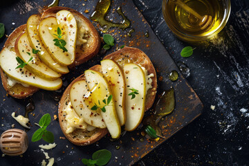 Sweet toast with pear cheese and honey on dark stone background, close up top view
